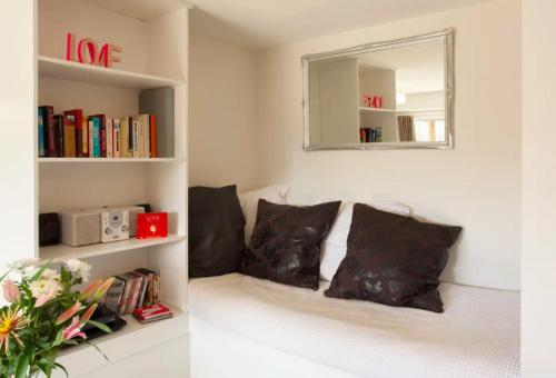 a living room with a couch with pillows and a mirror at The Love Spa in Queenstown