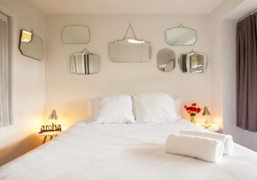a bedroom with a white bed with white sheets and mirrors at The Love Spa in Queenstown