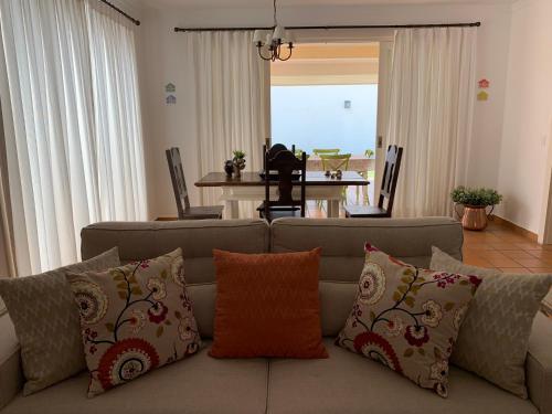 uma sala de estar com um sofá com almofadas em Villa Mare Residence em São Sebastião