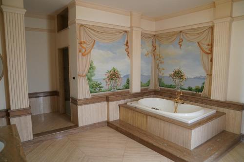 Villa Princi في فيلاّ سان جيوفاني: حمام كبير مع حوض استحمام ونافذة