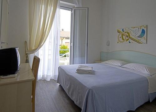 1 dormitorio con 1 cama, TV y ventana en Hotel Vienna, en Bellaria-Igea Marina