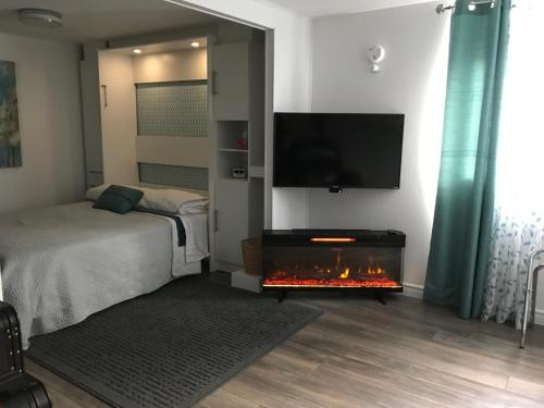 sypialnia z łóżkiem i kominkiem z telewizorem w obiekcie le Loft Québec w mieście Quebec City
