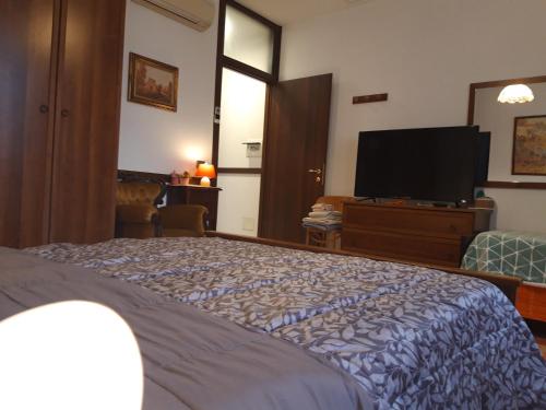 a bedroom with a bed and a flat screen tv at BorgoAntico Affittacamere in Soave