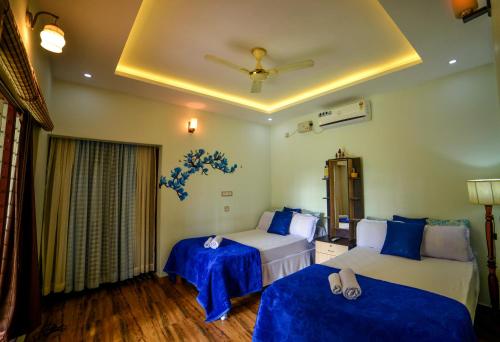 1 dormitorio con 2 camas y techo en Amritham Holidays Homestay Trivandrum en Thiruvananthapuram