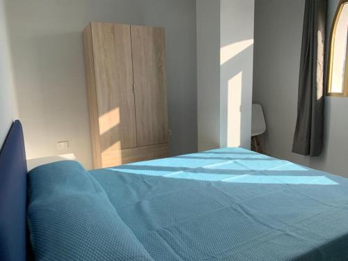 um quarto com uma cama azul e uma porta em FABULOSO apto. 6 pax, TABLERO 7, cerca de PLAYA INGLÉS em El Tablero