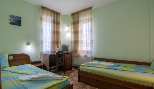Family Hotel Iv في فيلينغراد: غرفة فندقية بسريرين ومكتب