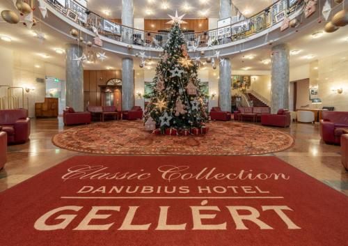 a large room with a large christmas tree in it at Danubius Hotel Gellért in Budapest