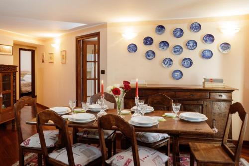 a dining room with a table and blue plates on the wall at Maison Paquier - Central Family Escape in Valtournenche