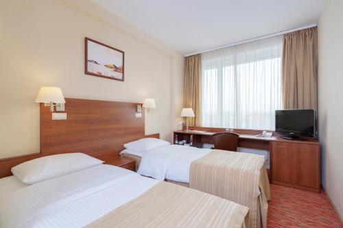 Un pat sau paturi într-o cameră la Maxima Panorama Hotel