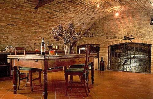 una cucina con tavolo, sedie e muro di mattoni di Locanda Martelletti a Cocconato