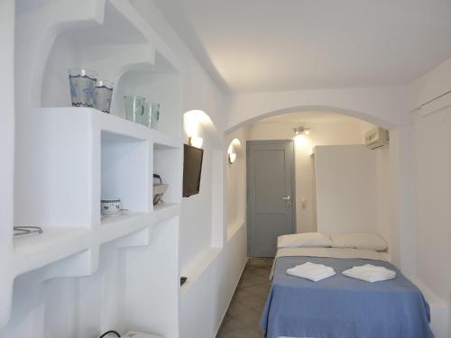 Habitación blanca pequeña con cama y lavamanos en Studio Balkoni, en Plaka Milou