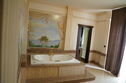 a large bath tub in a room with a painting at Villa Princi in Villa San Giovanni