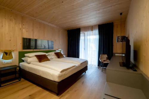 Tempat tidur dalam kamar di GästeHAUS & HOFladen Familie Öllerer