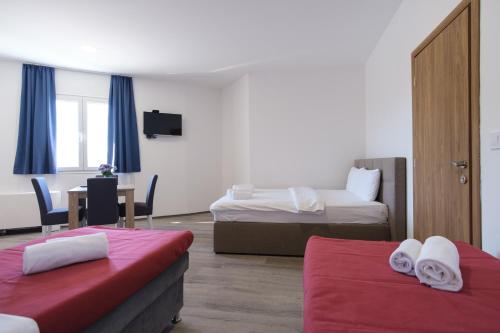 a hotel room with two beds and a table at SL OLIMP in Trebinje