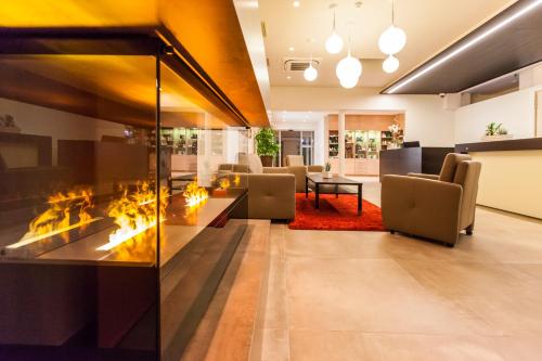 an open living room with a fireplace and chairs at Urdlwirt - Hotel & Restaurant in Premstätten