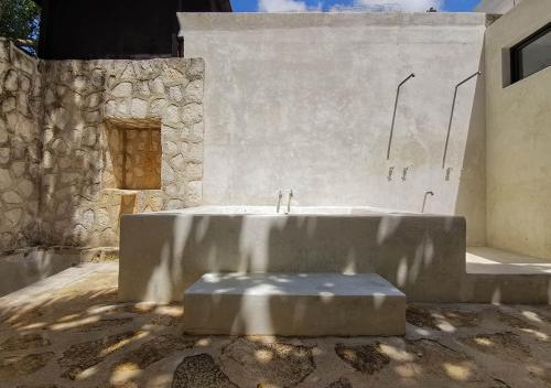 a large stone bench in front of a stone wall at Coqui Coqui Papholchac Coba Residence & Spa in Coba