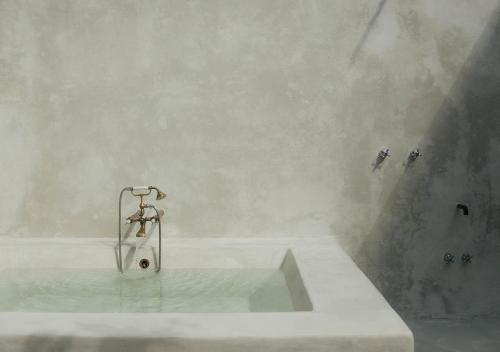 a bath tub with a shower with a faucet at Coqui Coqui Papholchac Coba Residence & Spa in Cob&aacute;