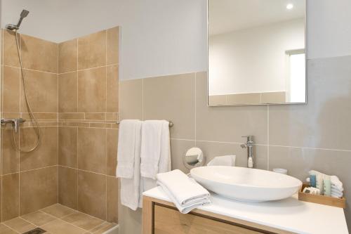 ein Badezimmer mit einem weißen Waschbecken und einer Dusche in der Unterkunft Bleu Emeraude Hotel in Grand Case