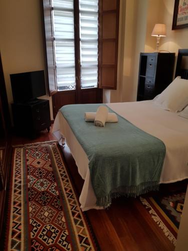 a bedroom with a bed with two towels on it at PISO DE CALIDAD EN EL CENTRO DEL CENTRO DE GIJON in Gijón