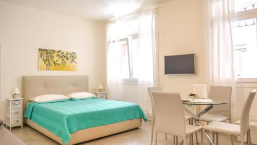1 dormitorio con 1 cama, mesa y sillas en Ca' due Olivi, en Toscolano Maderno