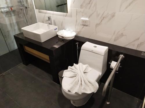 a bathroom with a toilet and a sink at Hotel De Sripoom in Chiang Mai