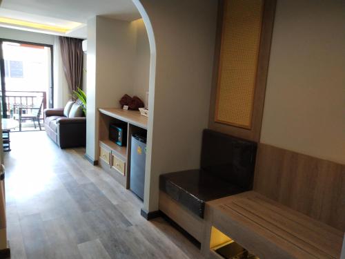 a living room with a couch and a television at Hotel De Sripoom in Chiang Mai