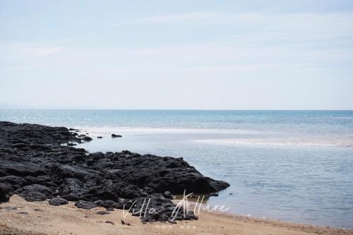 a beach with some rocks and the ocean at Villa Allure Koh Mak in Ko Mak