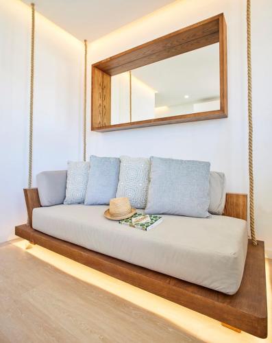 a couch sitting in a room with a mirror at Areias Senses in Albufeira