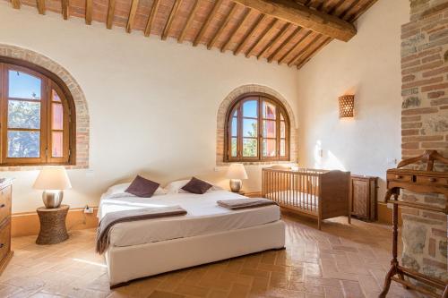 a bedroom with two beds and a crib at Villa Casenovole in Murlo