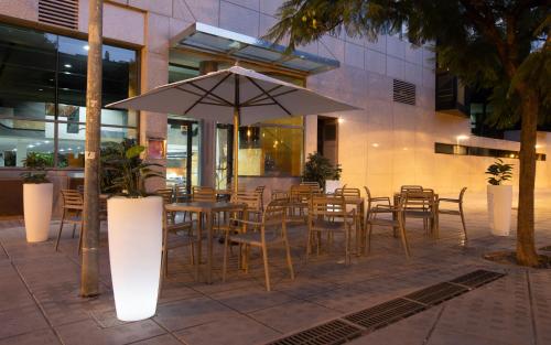 a restaurant with a table and chairs and an umbrella at Eurostars Acteón in Valencia
