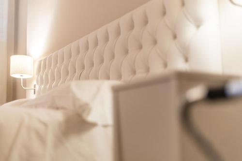 a white bed with a lamp next to it at Europa Palace Hotel in Messina
