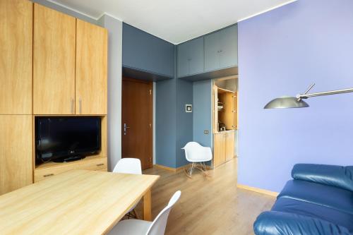 un soggiorno con tavolo e divano blu di Nizza26 Serviced Apartments a Torino