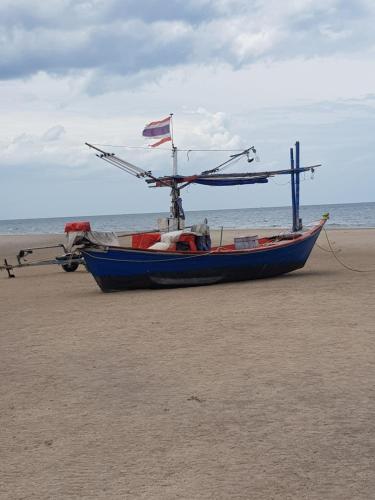 a blue boat sitting on the sand on the beach at Plaza Huahin in Hua Hin