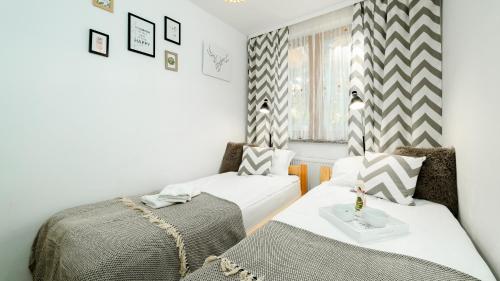 カルパチにあるApartament Karkonoszeのベッド2台と窓が備わる小さな客室です。