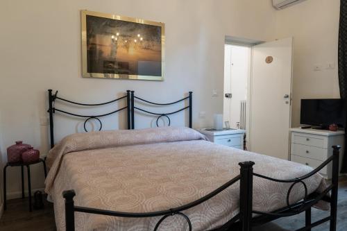 a bedroom with a large bed and a television at La casa di Alvy in Pescara