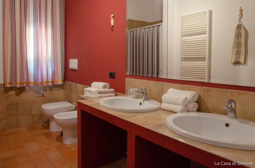 a bathroom with two sinks and a toilet and a mirror at B&B Terra Cesarea in Santa Cesarea Terme