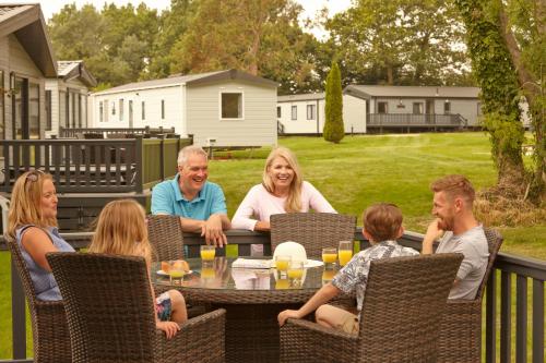 a group of people sitting around a table on a patio at St Helens Coastal Resort in Saint Helens