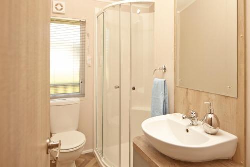 a bathroom with a toilet and a sink and a shower at St Helens Coastal Resort in Saint Helens