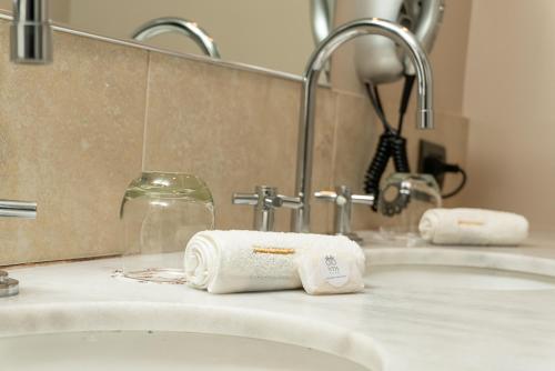 a bathroom sink with two rolled towels on it at Neuquén Tower Hotel in Neuquén