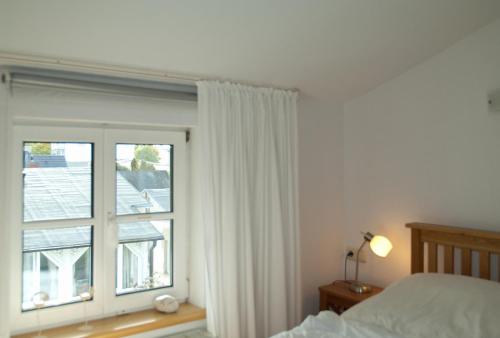 ein Schlafzimmer mit einem Bett und einem großen Fenster in der Unterkunft Wohnung 5 Haus Borgwardt in Göhren