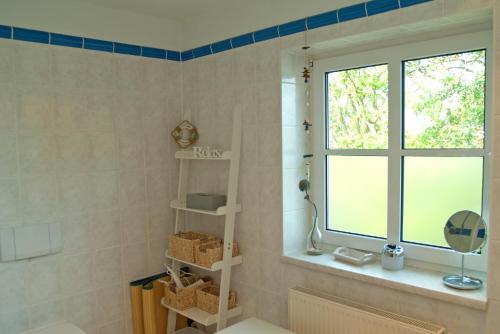 ein Badezimmer mit Waschbecken und Fenster in der Unterkunft Wohnung 5 Haus Borgwardt in Göhren
