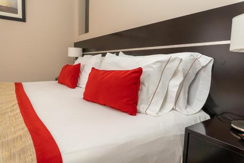 a bedroom with a bed with red and white pillows at Neuquén Tower Hotel in Neuquén