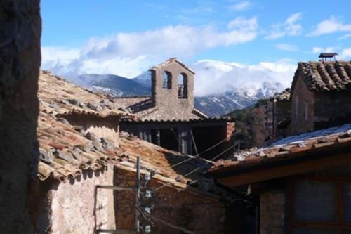 eine Gruppe von Gebäuden mit Bergen im Hintergrund in der Unterkunft Cal Tomàs in Ossera