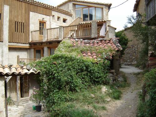 ein altes Haus mit Balkon seitlich in der Unterkunft Cal Tomàs in Ossera