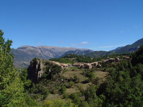 ein Dorf auf einem Hügel mit Bergen im Hintergrund in der Unterkunft Cal Tomàs in Ossera