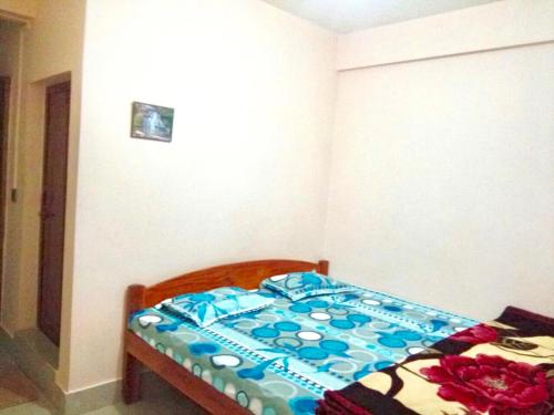 a bedroom with a bed with a blue and white comforter at Pine Hill Home Stay in Shillong