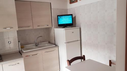 een keuken met een tv bovenop een koelkast bij Casa Vacanze Yuli in Rome