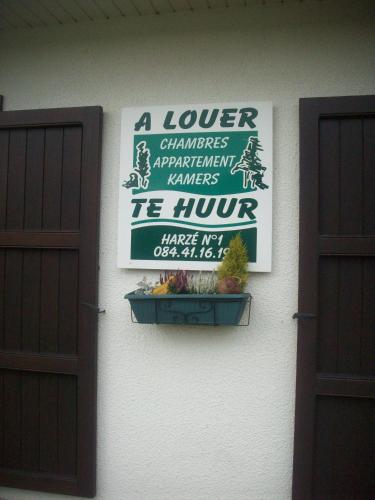 a sign on the side of a building with two doors at Chez Lola in La Roche-en-Ardenne