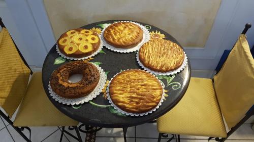 uma mesa com quatro bolos em cima em Hotel Sangiuliano 132 centro storico Catania em Catânia