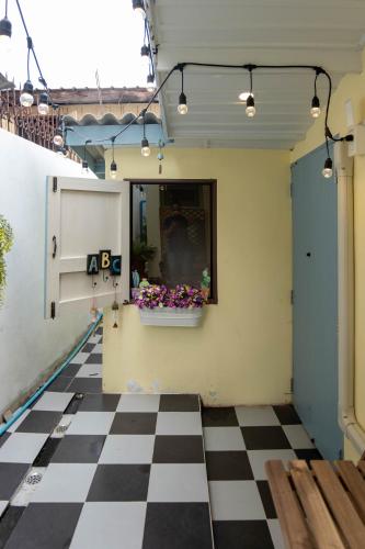a room with a checkered floor and a flower pot on the wall at Baan Suan Krung Kao in Phra Nakhon Si Ayutthaya